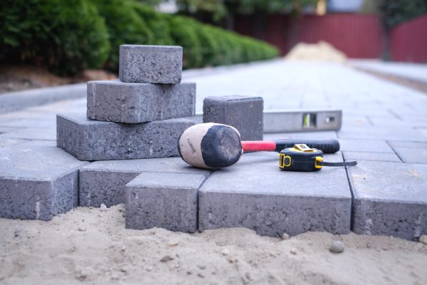 Paving stones pathway paving background. Installing tools on foreground